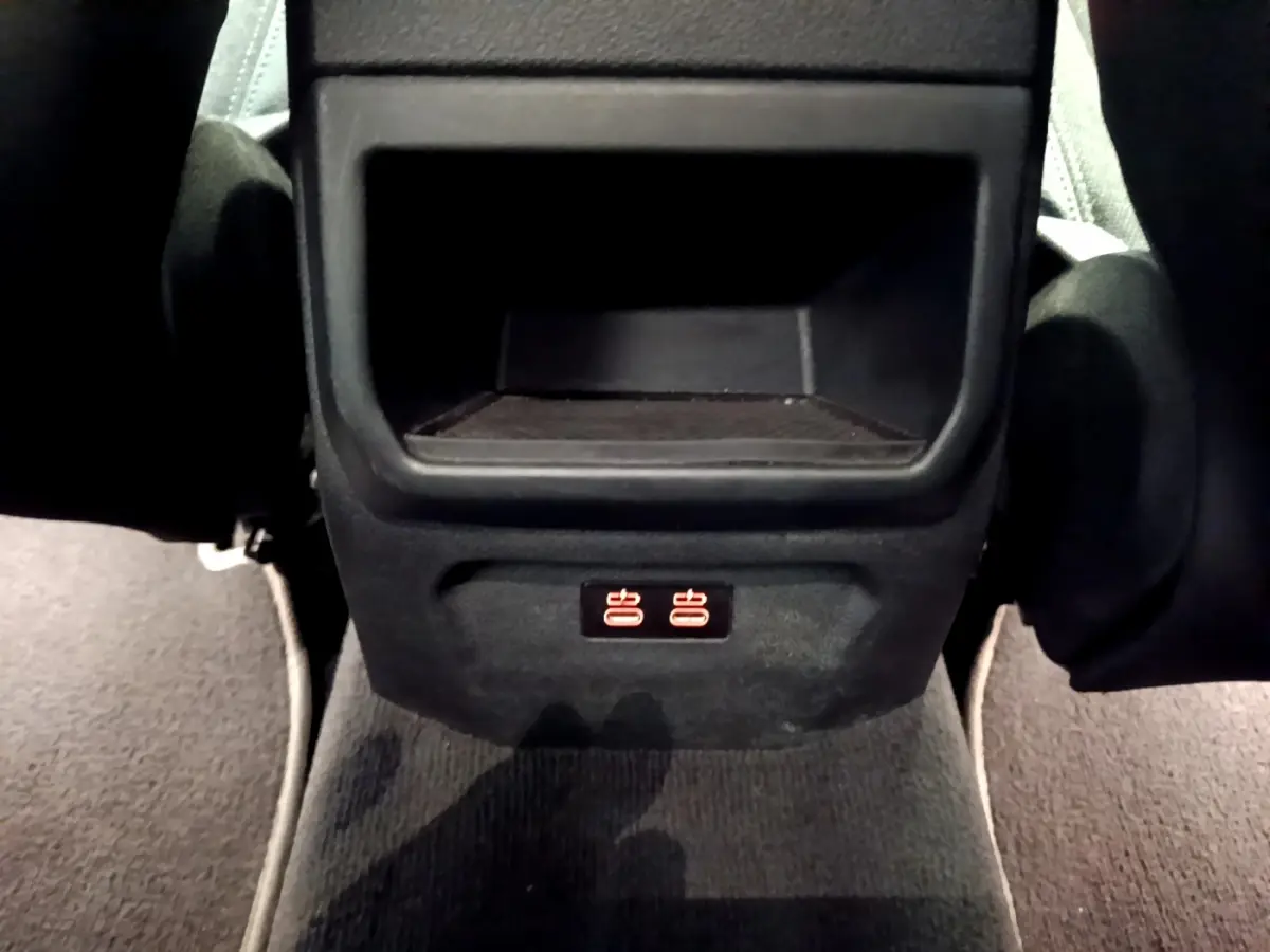 Prise USB arrière illuminée sous le rangement central des sièges arrière d'une BMW Série 1 gris clair.