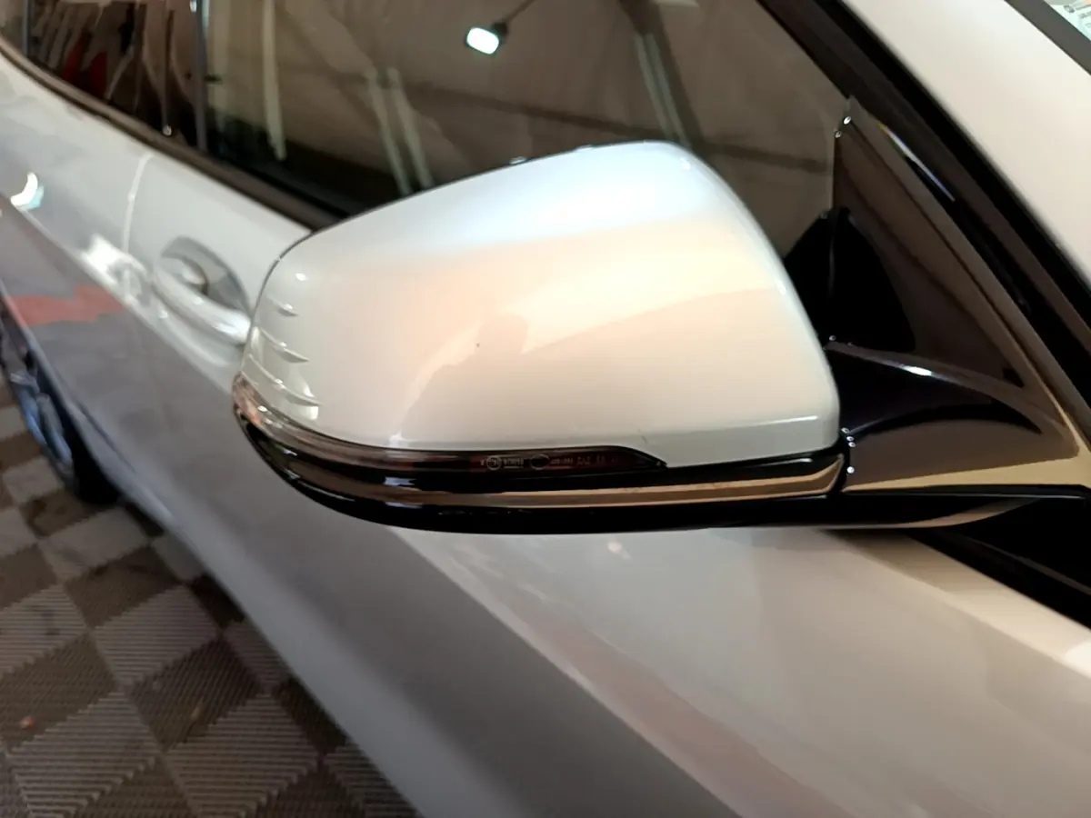 Gros plan sur le rétroviseur droit gris clair de la BMW Série 1 Edition Sport 2021 avec clignotant intégré.