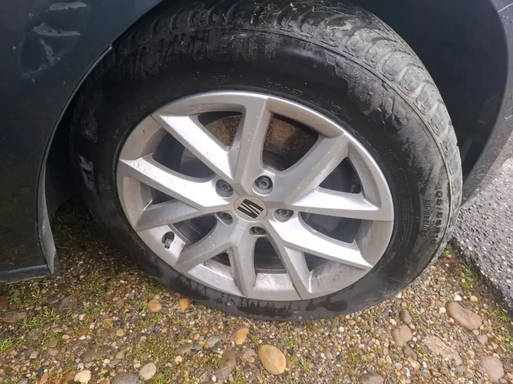 Gros plan sur la roue avant droite d'une SEAT LEON gris 2021 avec jante alliage et logo central visible.