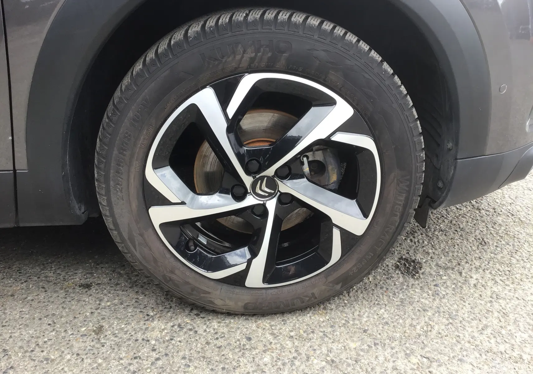 Gros plan sur la roue avant droite d’un Citroën C5 Aircross gris platinium avec jante alliage noire et argentée.