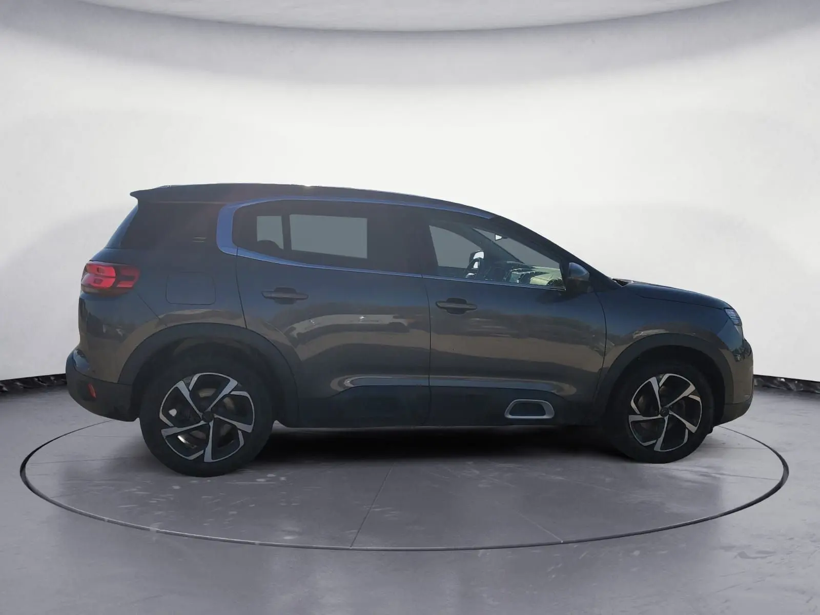 Vue de profil côté gauche d'un Citroën C5 Aircross gris platinium avec jantes bi-ton et protections noires.