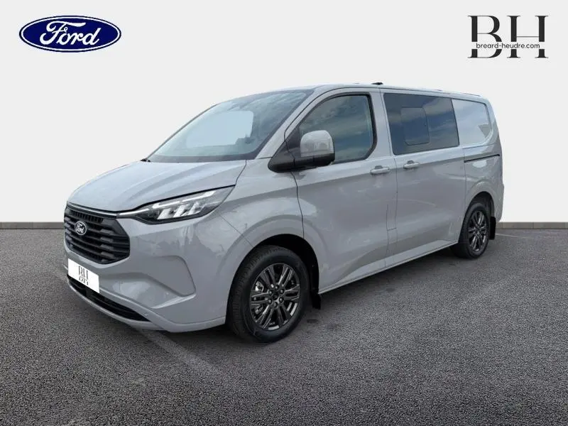 Vue 3/4 avant droit du Ford Transit Custom Fourgon gris Matter Spéciale avec jantes alu gris carbone et vitres arrière surteintées.