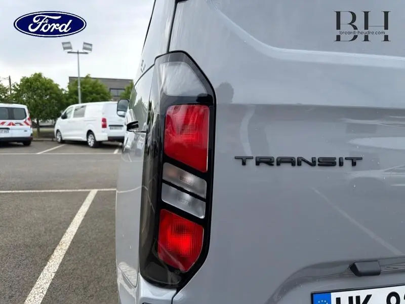 Gros plan sur le feu arrière gauche du Ford Transit Custom gris Matter Spéciale, avec logo et partie arrière visible.