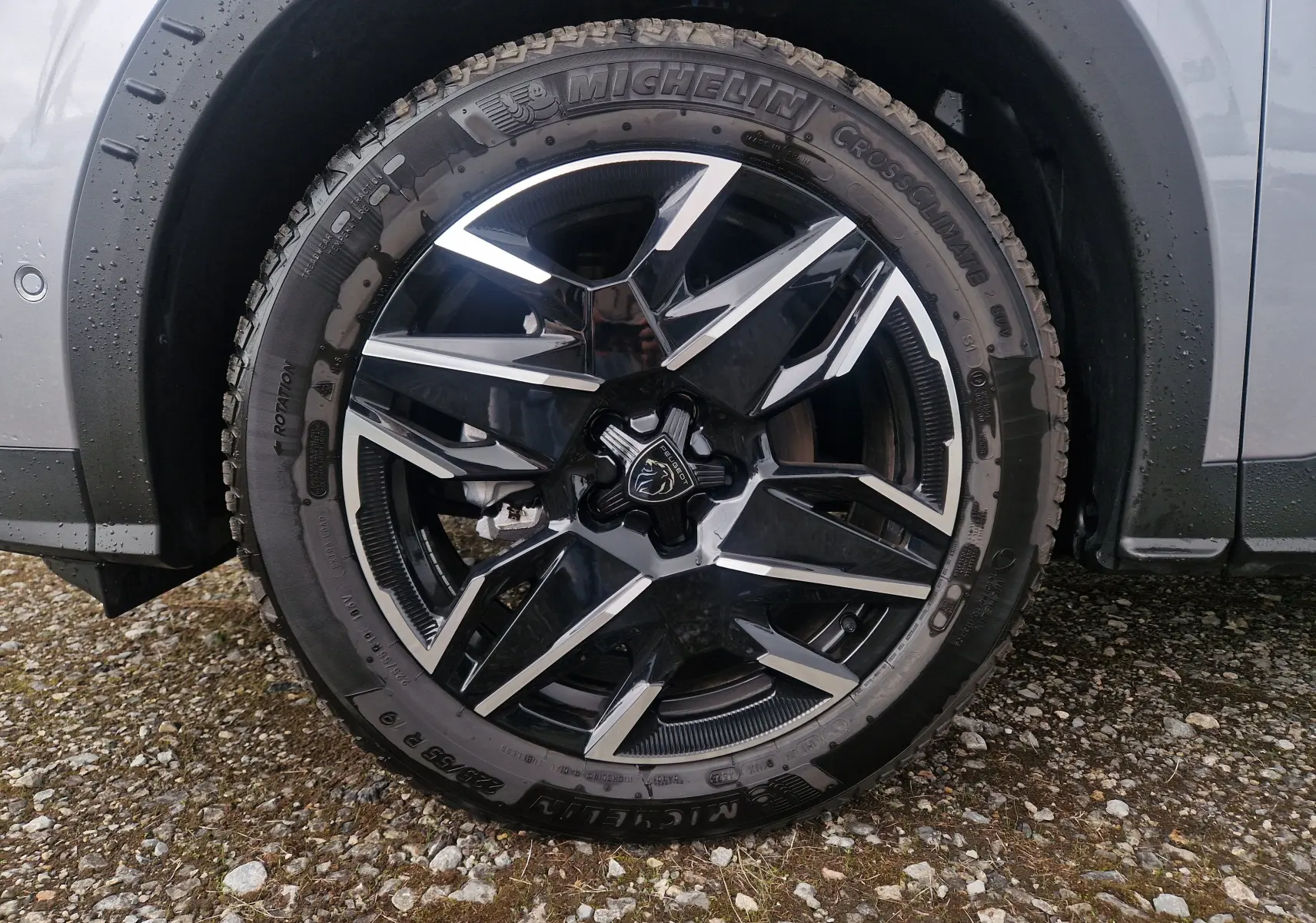 Gros plan sur la roue avant droite du Peugeot 3008 gris Artense, jante alliage noire et argentée au design géométrique.
