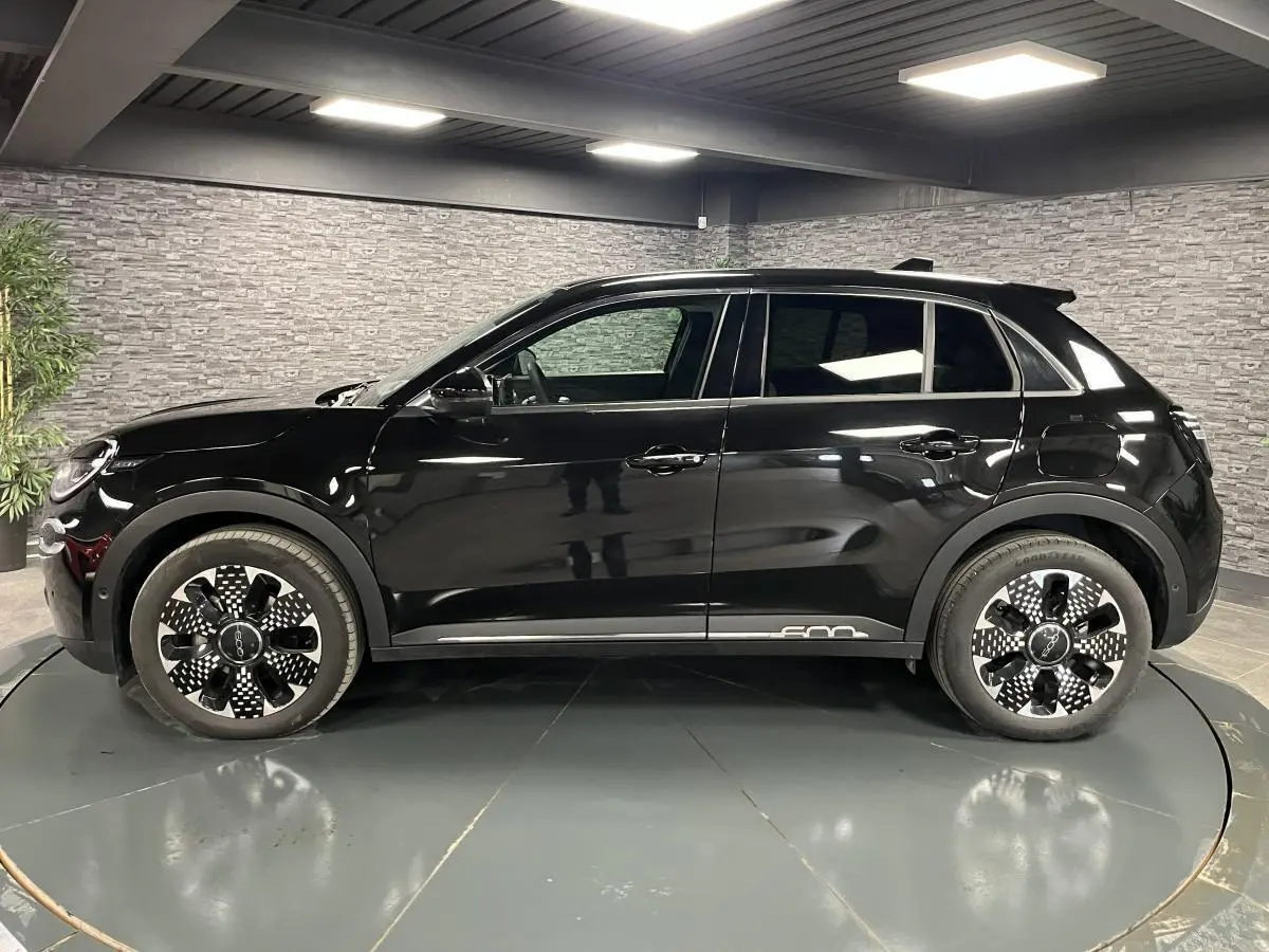 Profil côté gauche d'une FIAT 600 noire 2024 avec jantes alliage diamantées et logo 600 chromé sur bas de caisse