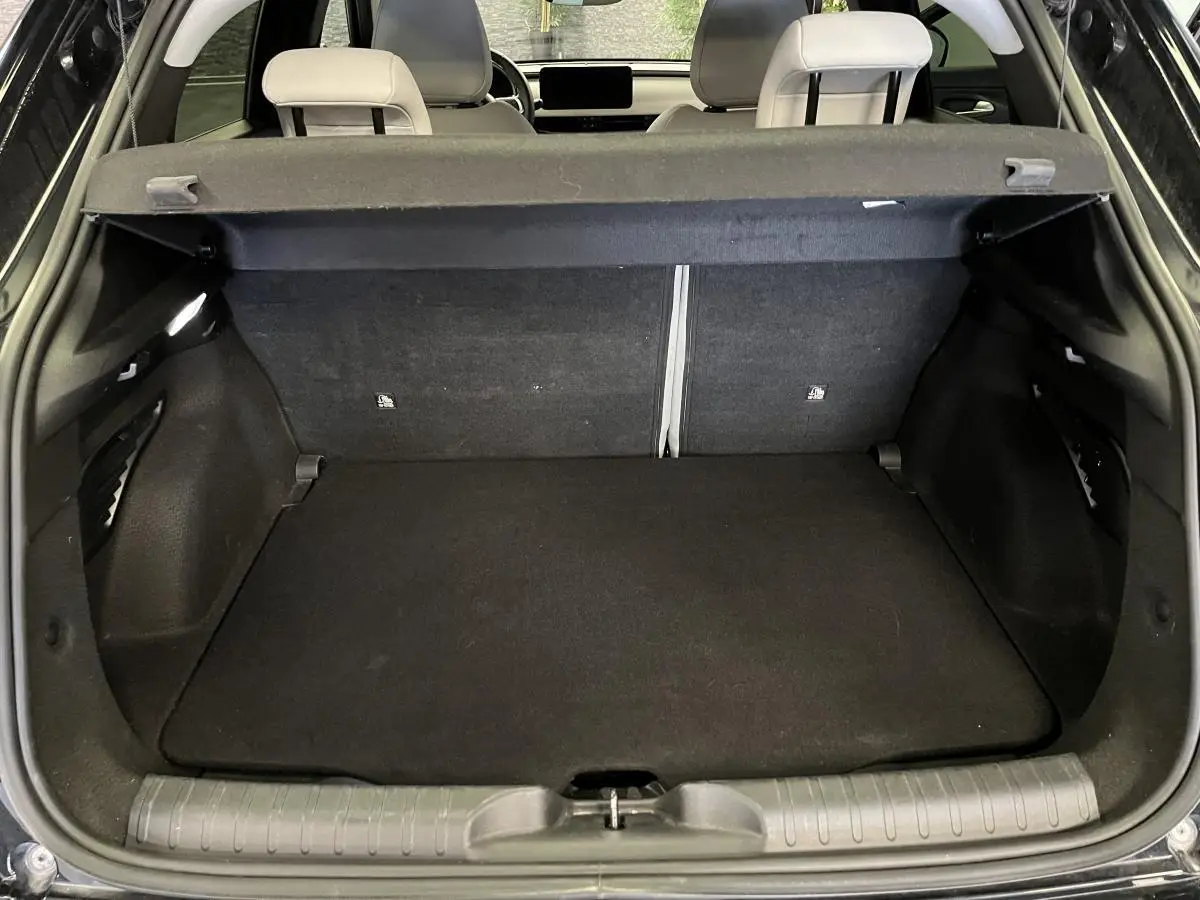 Coffre ouvert vu de l'arrière d'une FIAT 600 noire, montrant l'espace de chargement et la banquette arrière.
