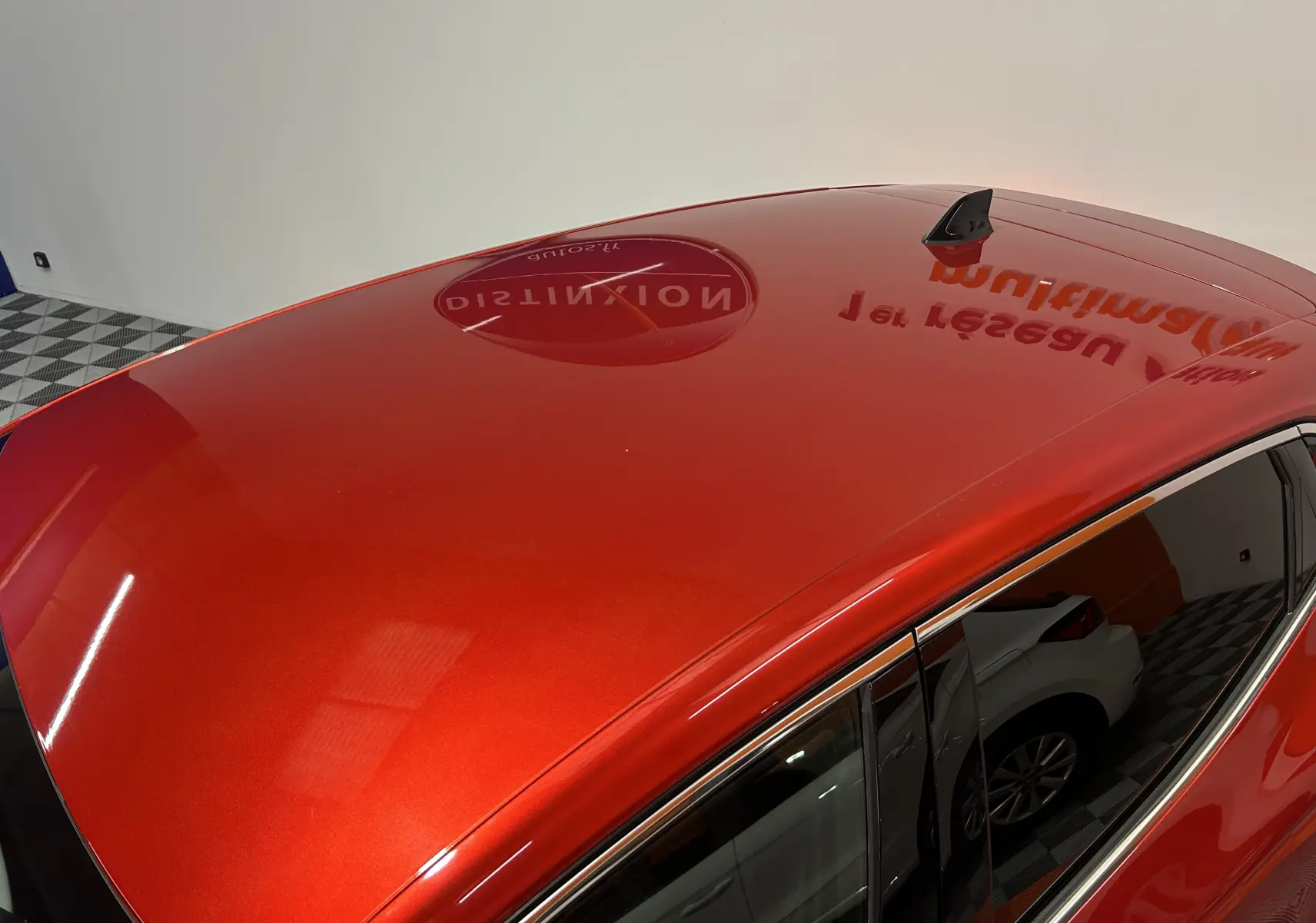 Toit rouge brillant de la Renault Clio V TCe 90 TECHNO vue en plongée avec antenne requin noire.