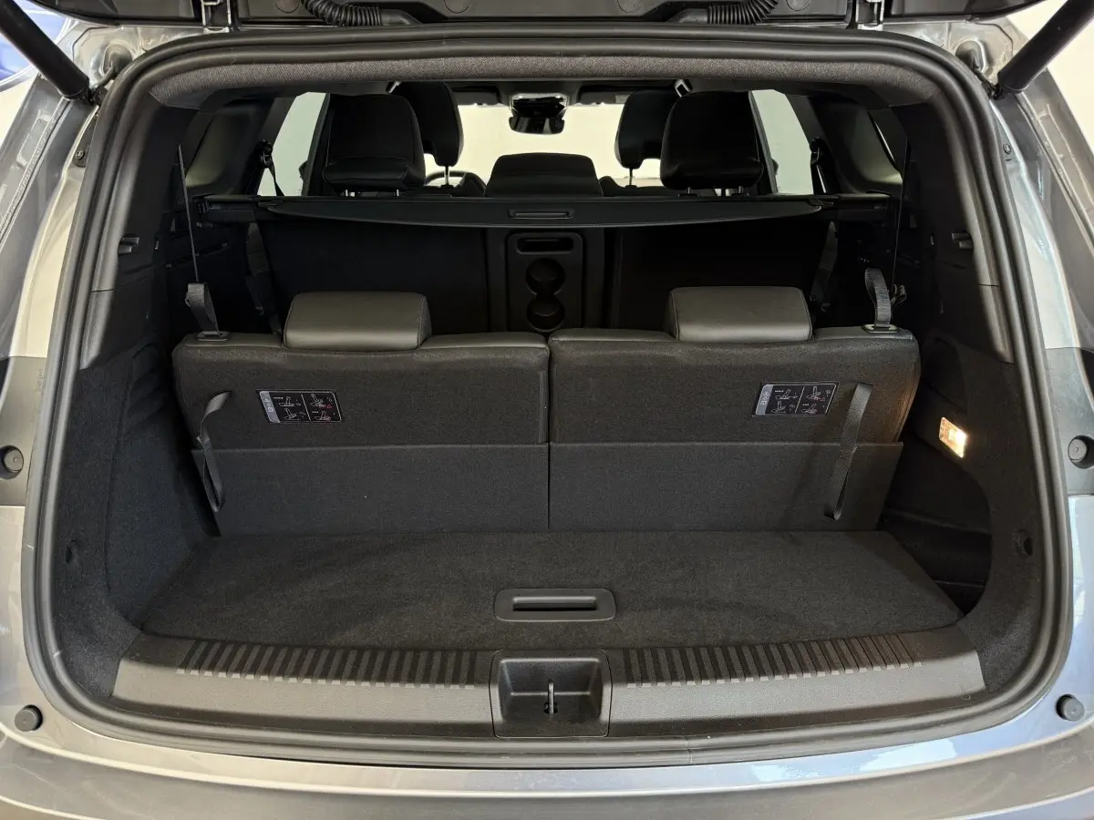 Coffre ouvert vu de l'arrière du Renault Espace gris foncé 2025 avec 3ème rangée de sièges rabattables et plancher plat.