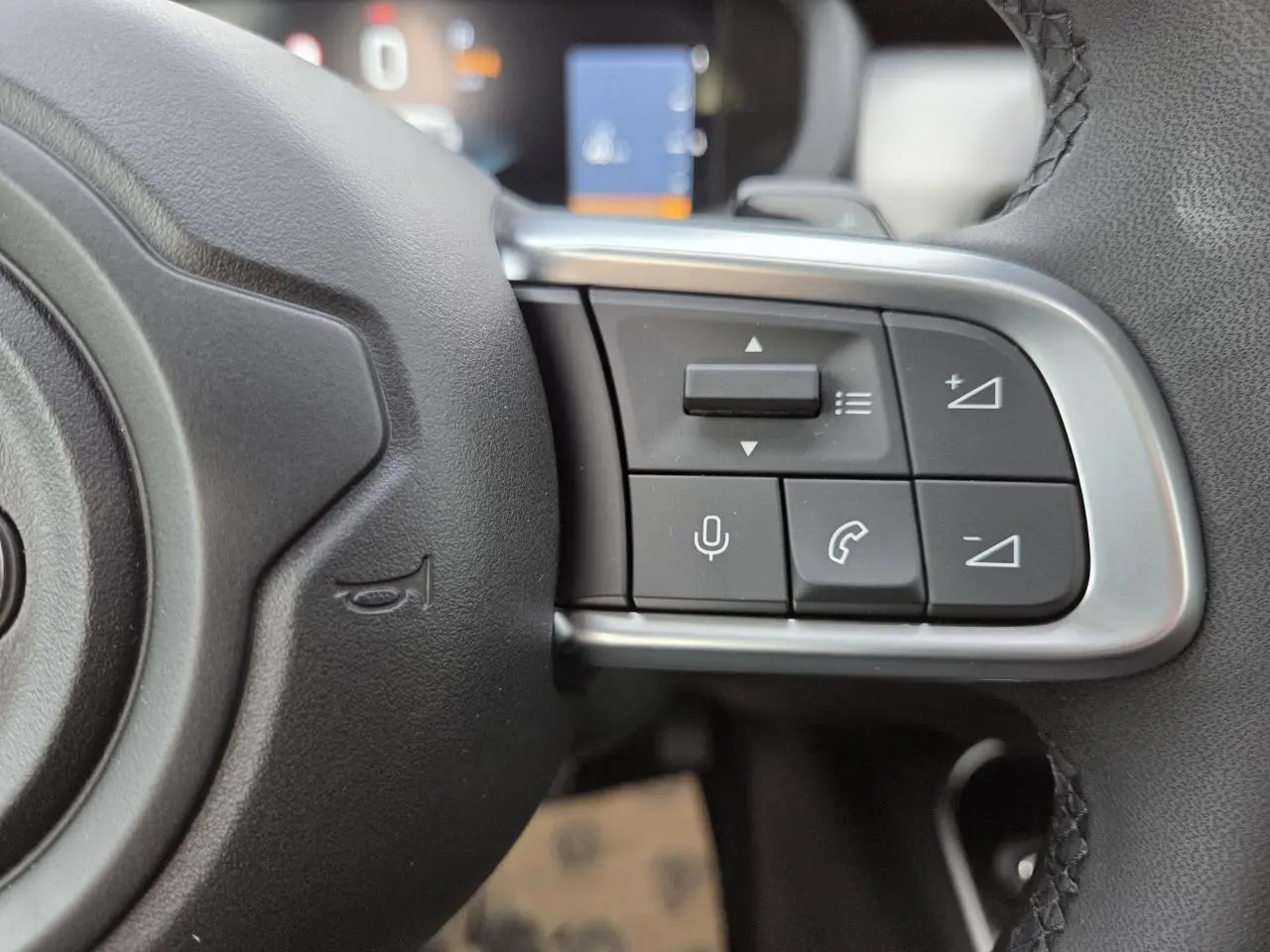 Gros plan sur les commandes vocales et téléphoniques au volant en TEP noir du Jeep Avenger 2025.