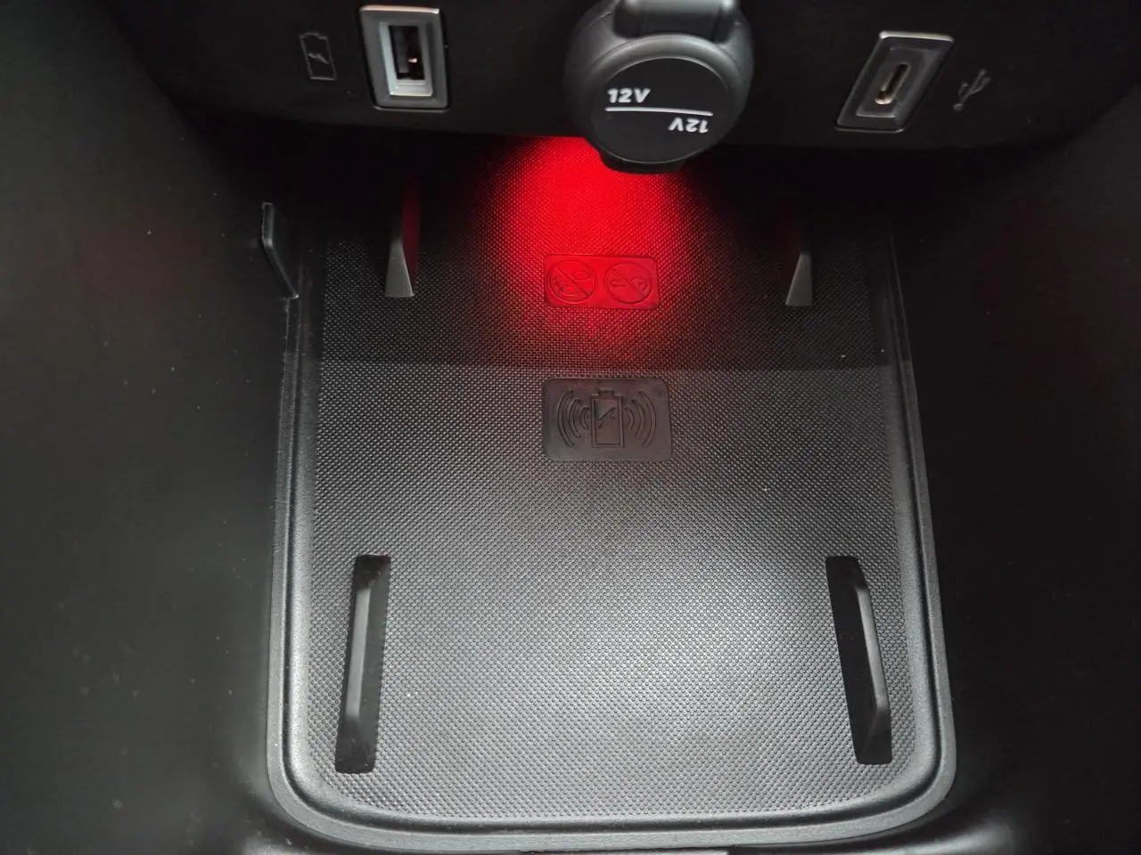 Gros plan sur le chargeur sans fil et prises USB dans la console centrale du Jeep Avenger 2025 finition Summit.