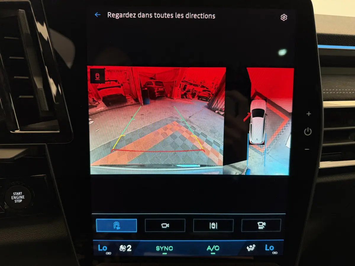 Écran tactile du tableau de bord du Renault Espace gris foncé 2025 montrant la caméra de recul et l'aide au stationnement.