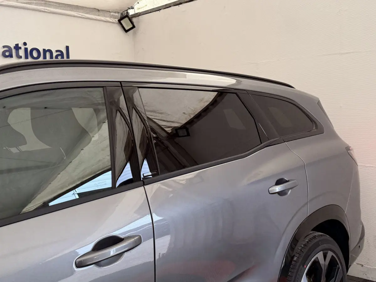 Vue latérale droite du Renault Espace gris foncé esprit Alpine 7 places, mettant en valeur ses vitres teintées et poignées de porte intégrées.