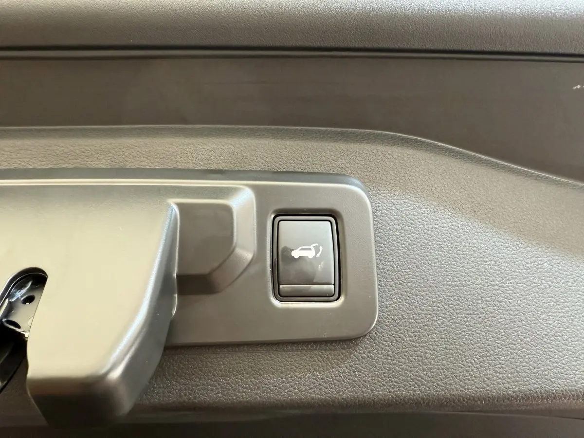 Bouton d'ouverture électrique du coffre sur la garniture intérieure du Renault Espace gris foncé esprit Alpine 2025.