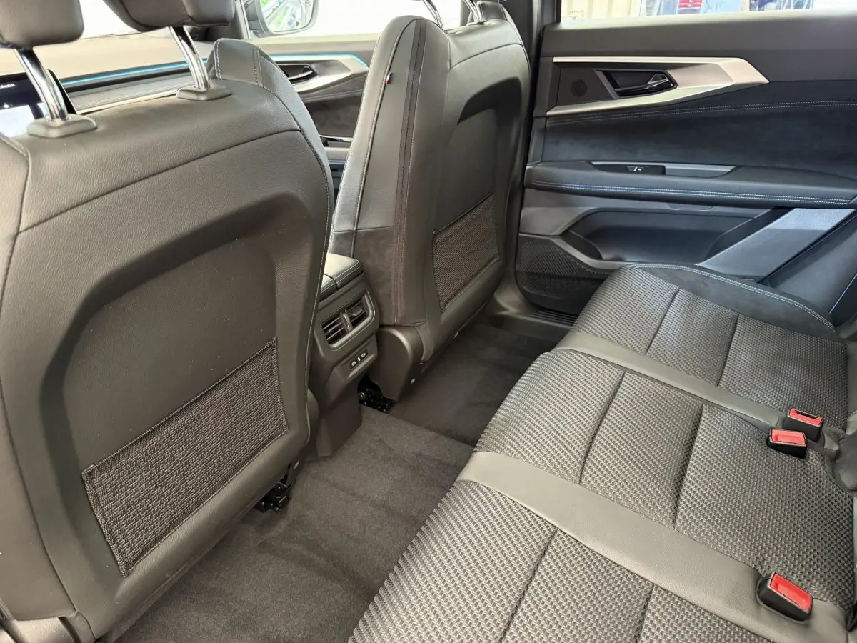 Vue intérieure arrière côté droit du Renault Espace gris foncé, sièges en tissu et cuir avec finitions modernes.