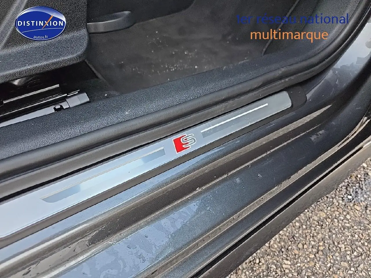 Gros plan sur la plaque de seuil de porte avec logo S de l'Audi A3 Sportback 45 TFSI e gris Daytona côté gauche.