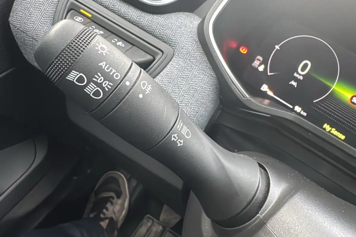 Gros plan sur la commande des feux et clignotants dans l’habitacle gris de la Renault Clio V TCe 90 Techno Plus 2025.