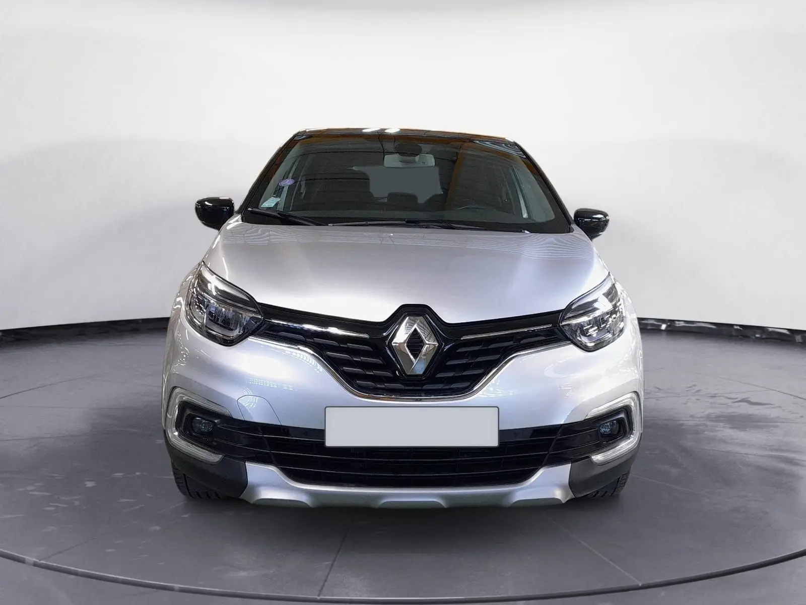 Vue frontale d'un Renault Captur TCE 120 Energy Iridium gris clair métal avec toit noir et calandre noire brillante.