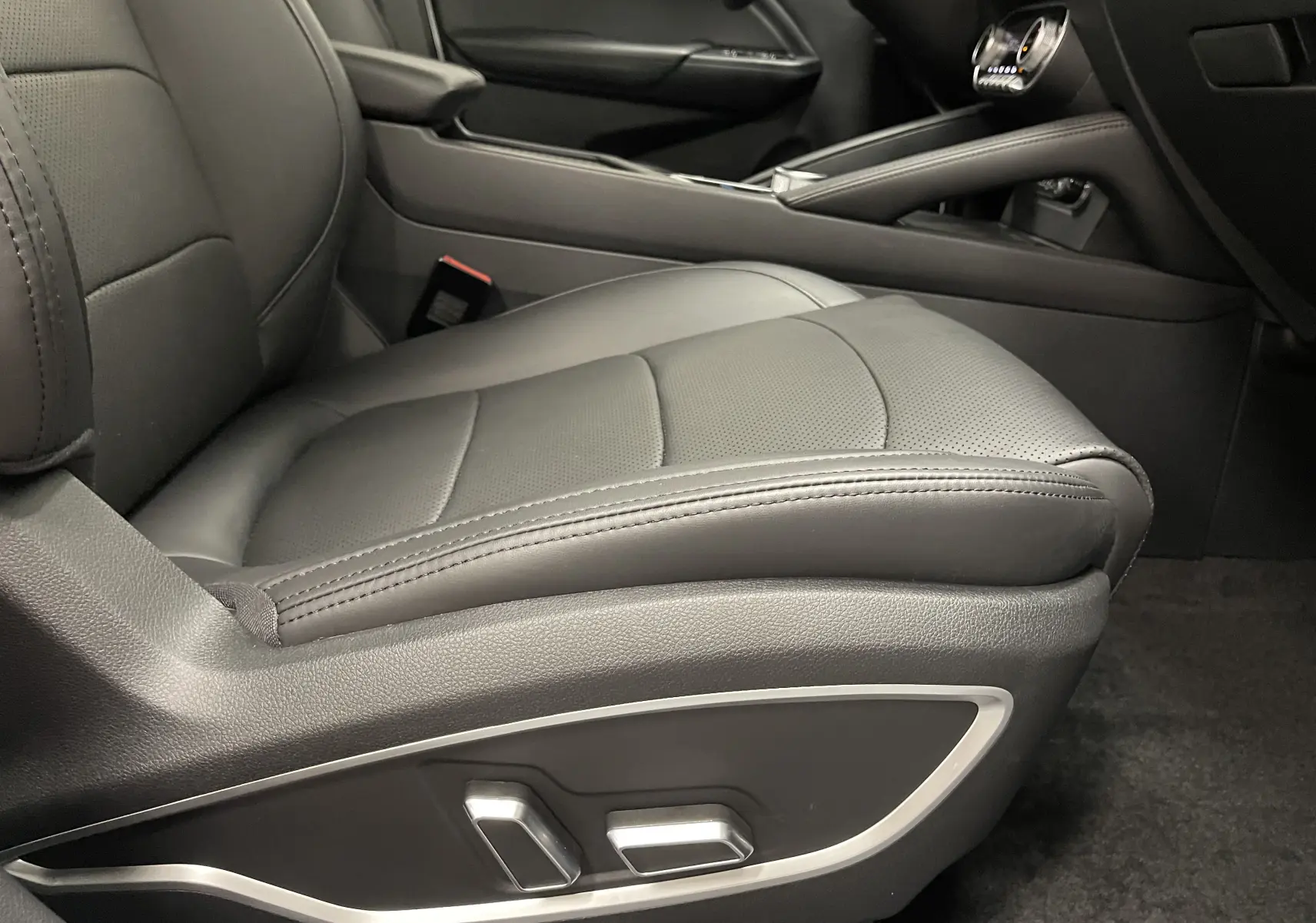 Gros plan sur le siège conducteur noir électrique du SERES 3 Luxury, mettant en valeur les commandes de réglage sur le côté.