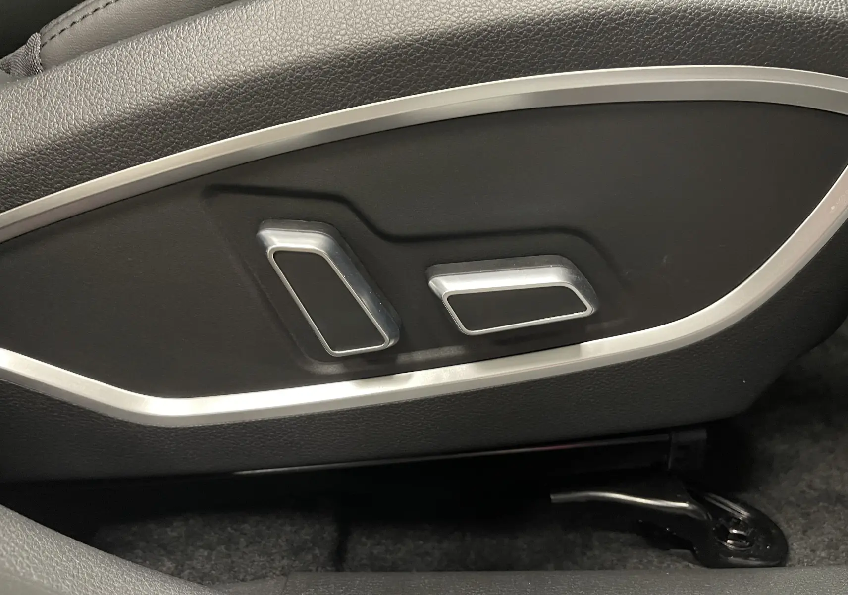 Détail des commandes électriques de réglage du siège côté conducteur dans l'habitacle noir du SERES 3 Luxury blanc électrique.