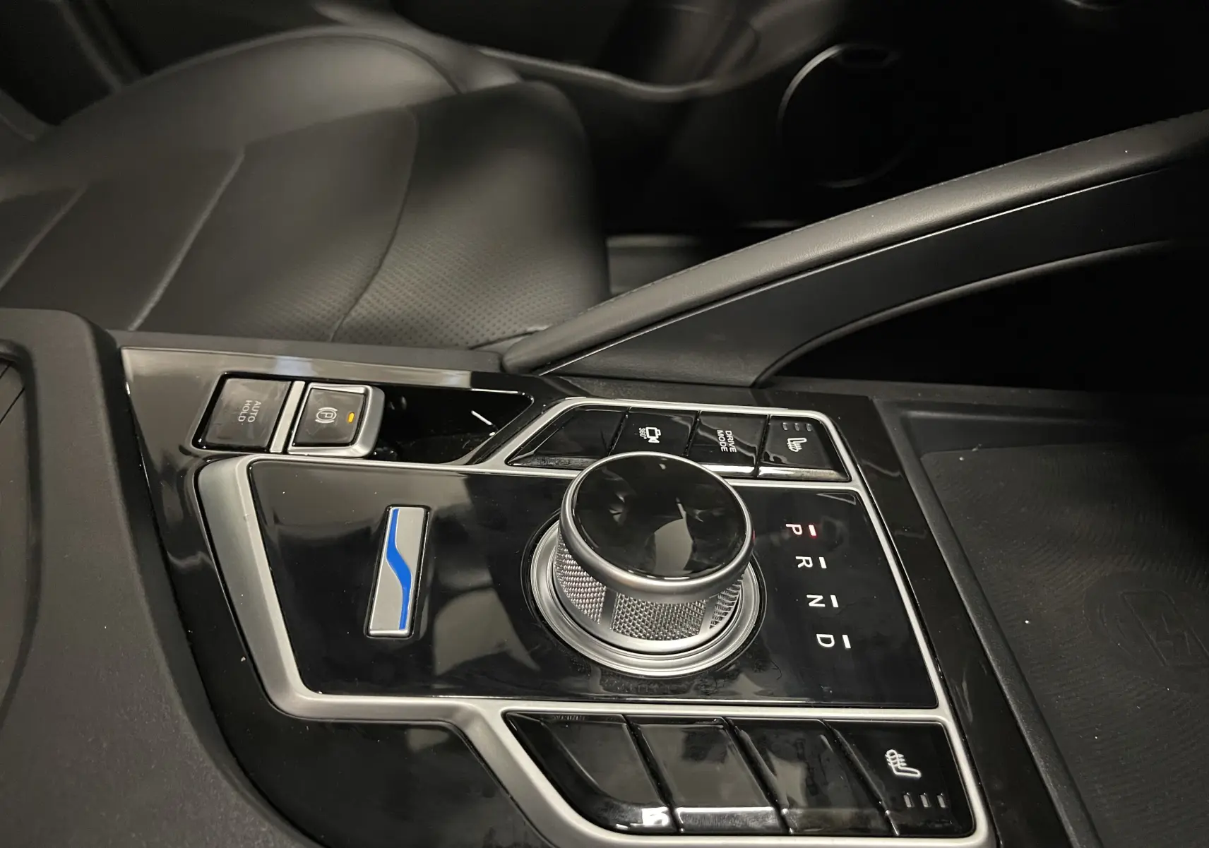 Gros plan sur la console centrale noire du SERES 3 Luxury blanc, mettant en valeur la molette de boîte auto et les commandes chauffantes.