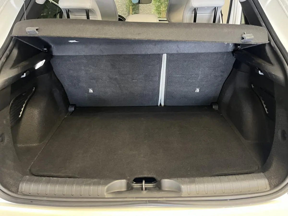 Coffre ouvert noir de la FIAT 600 1.2 Hybrid 2024 vue arrière avec banquette rabattable et cache-bagages.