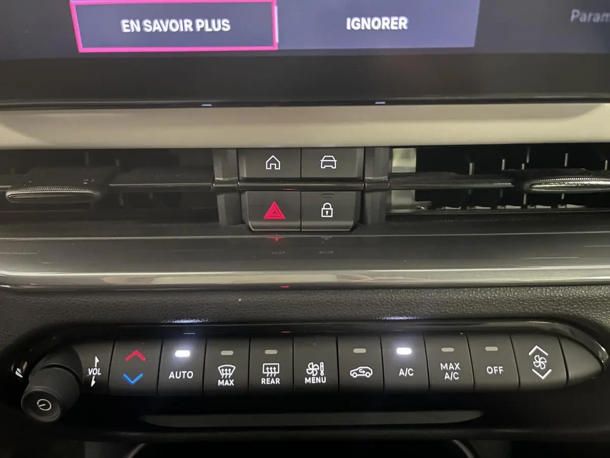 Détail de la console centrale noire avec commandes climatisation et boutons d'alerte du Fiat 600 blanc 2024.