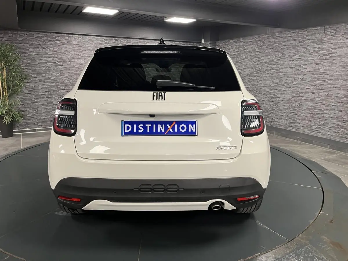 Vue arrière d'une FIAT 600 blanche 1.2 Hybrid 2024 avec feux LED et logo chromé sur hayon noir brillant