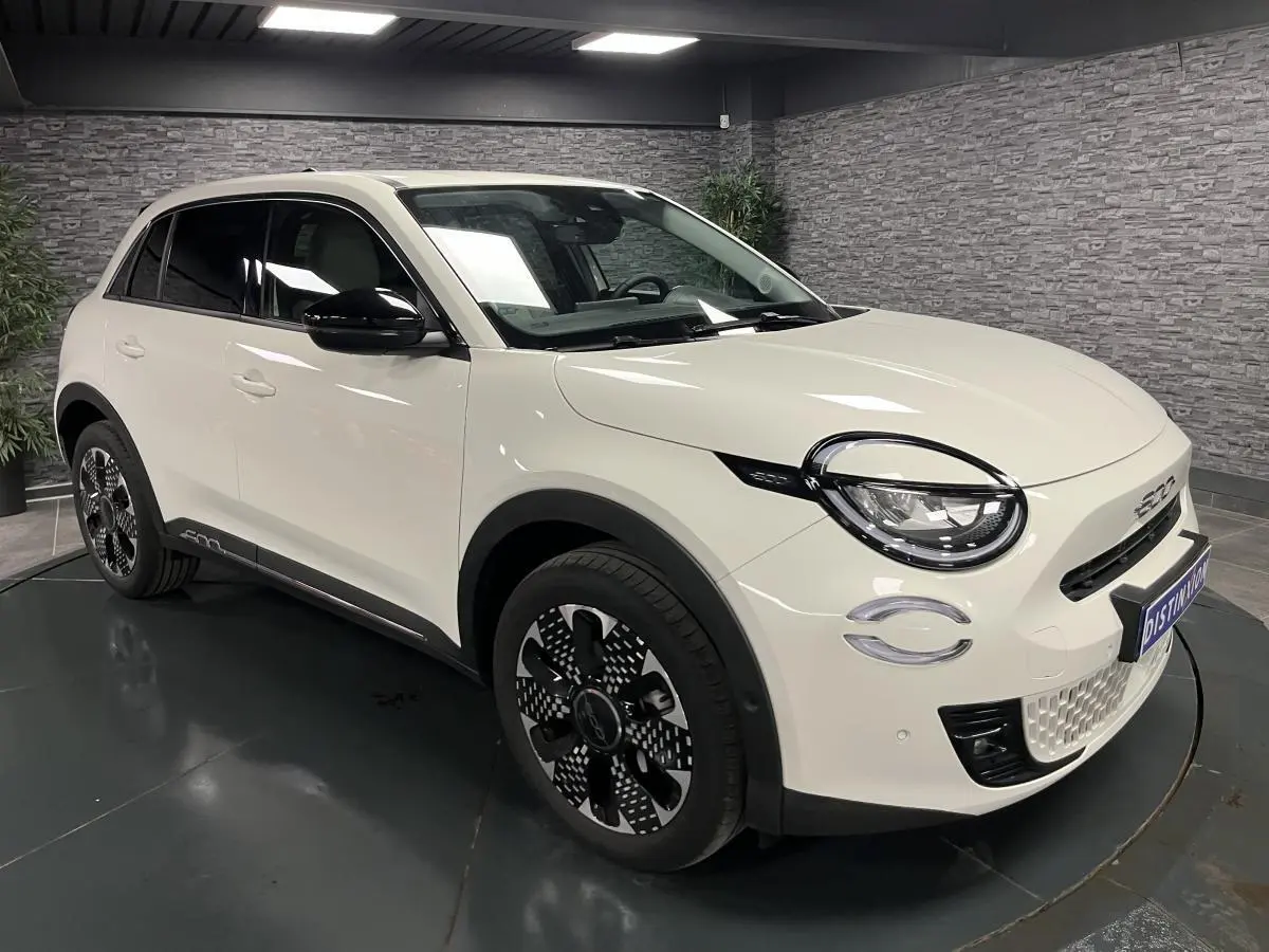 Vue 3/4 avant droite de la FIAT 600 blanche 2024 avec jantes alliage 18'' diamantées et phares LED Infinity.