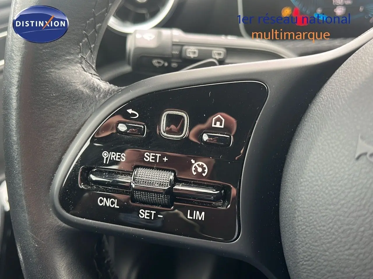 Gros plan sur les commandes de régulateur de vitesse au volant cuir noir d’une Mercedes CLA Shooting Brake argent iridium.