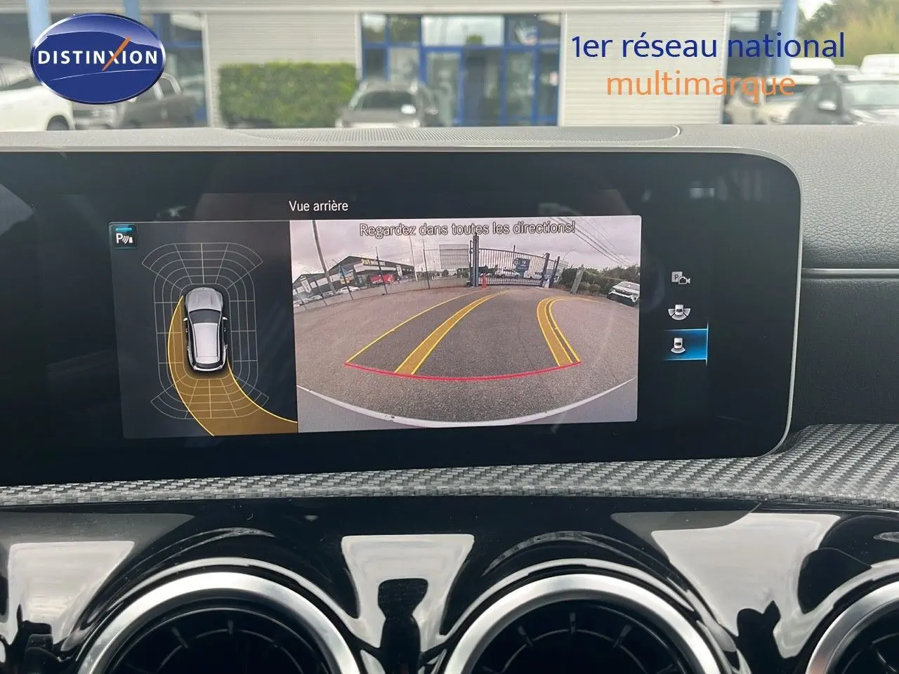 Écran intérieur montrant la caméra de recul et les capteurs de stationnement d'une Mercedes CLA Shooting Brake argent iridium.