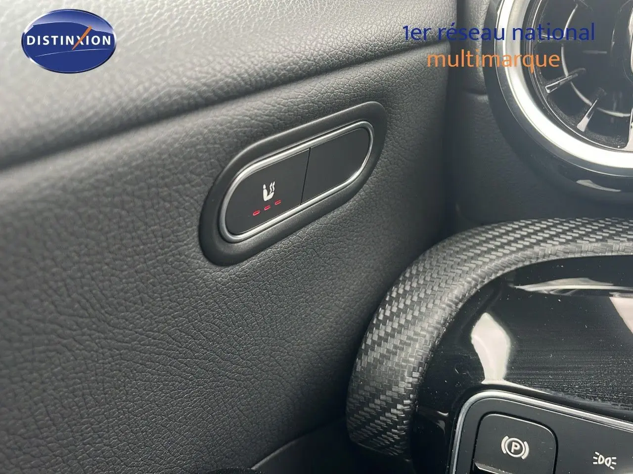 Gros plan sur le bouton de siège chauffant côté conducteur dans l'habitacle noir d'une Mercedes CLA Shooting Brake 2020.
