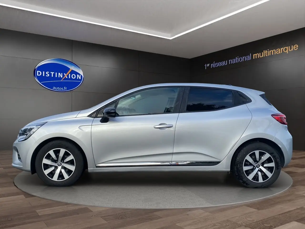 Profil côté gauche de la Renault Clio V gris Highland avec vitres arrière surteintées et jantes distinctives.