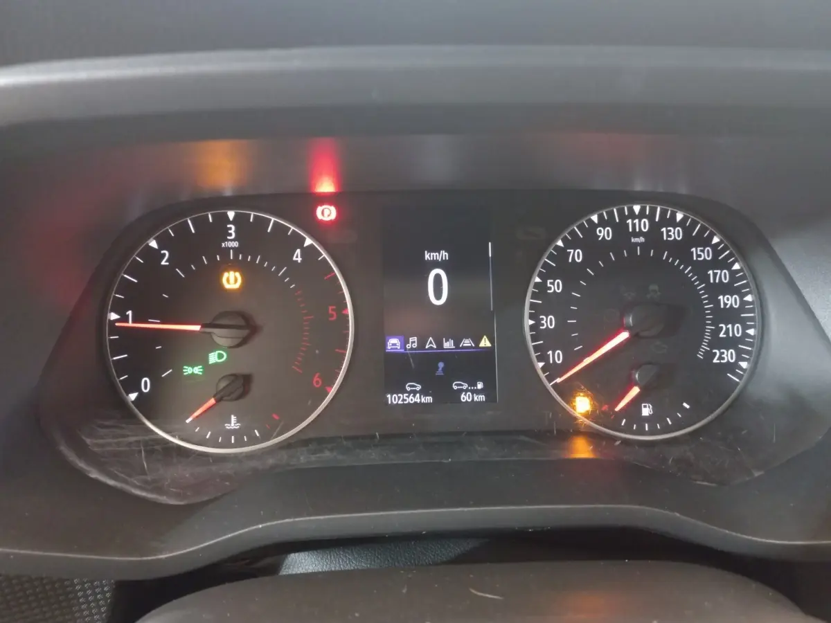 Vue rapprochée du tableau de bord numérique du Renault Trafic Fourgon blanc, affichant vitesse et compte-tours.