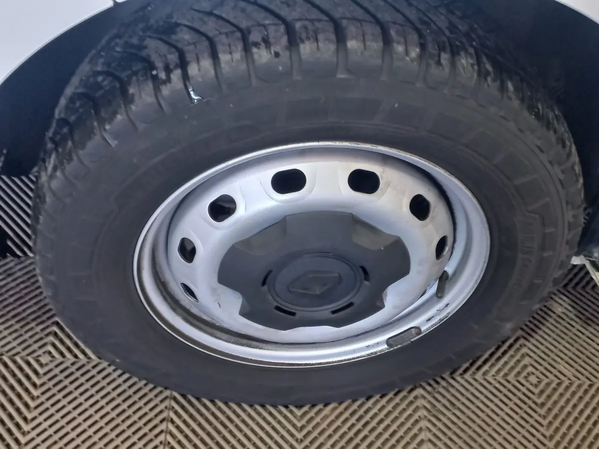 Gros plan sur la roue avant droite blanche du Renault Trafic Fourgon avec jante acier et logo Renault central.