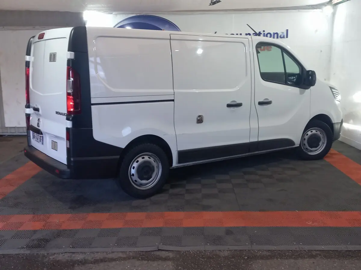 Renault Trafic Fourgon blanc vu de profil côté droit, avec portes latérales pleines et jantes acier simples.