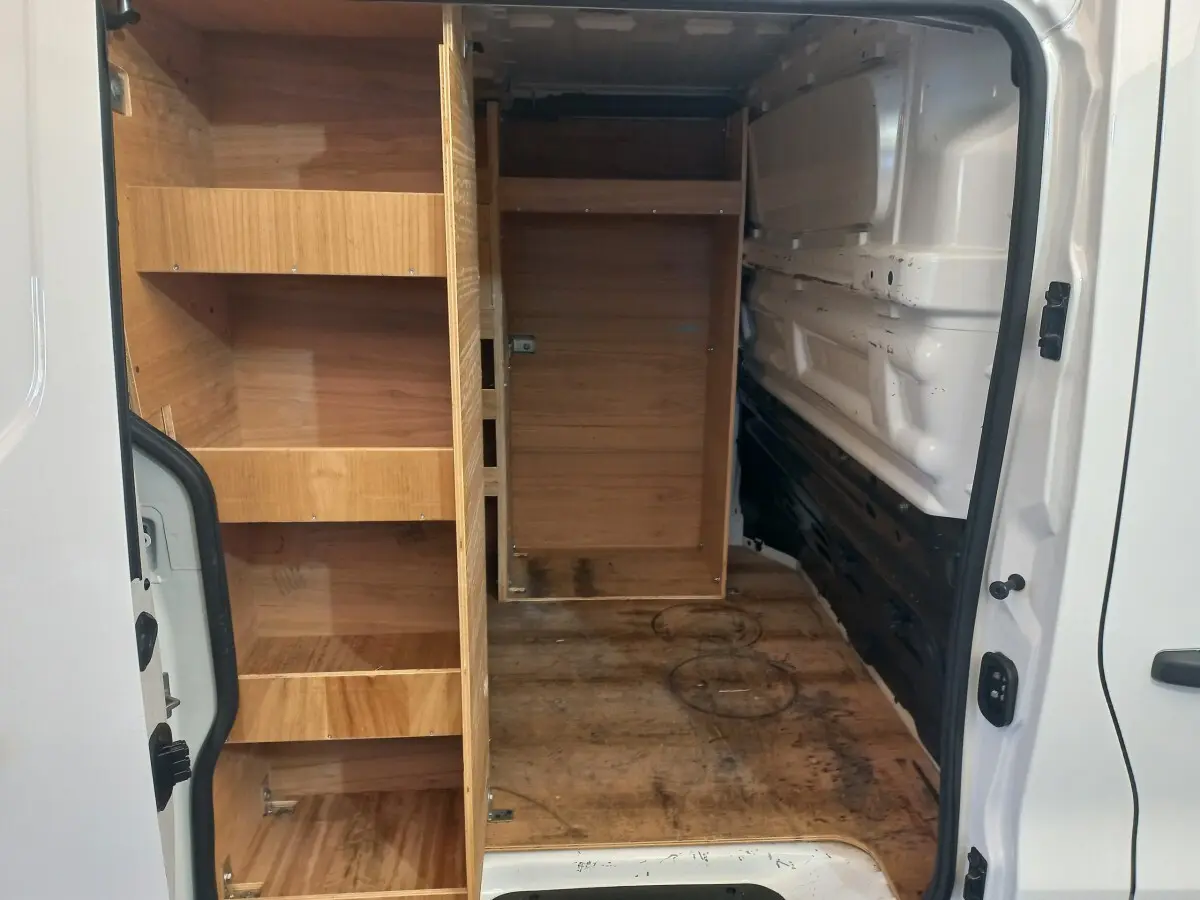 Vue intérieure arrière droite du Renault Trafic Fourgon blanc 2022 avec aménagements en bois et espace de chargement visible.
