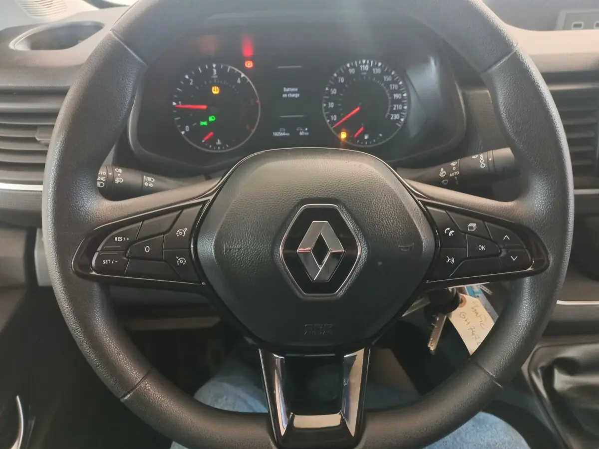 Vue rapprochée du volant noir multifonctions de Renault Trafic Fourgon 2022 avec tableau de bord et compteurs visibles.