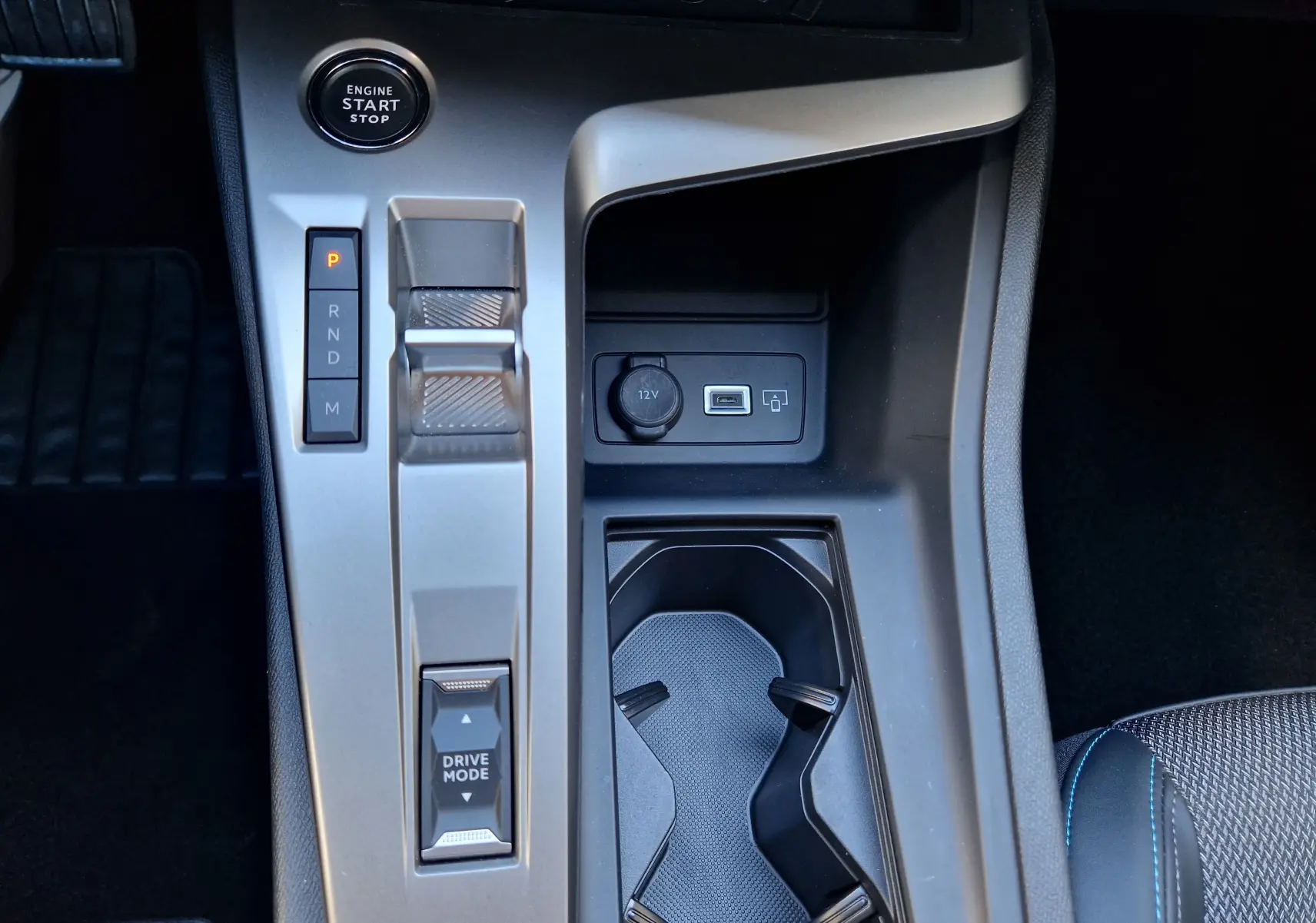 Vue rapprochée de la console centrale grise Artense du Peugeot 308 1.2 Hybrid 145 avec bouton start et commande boîte auto.