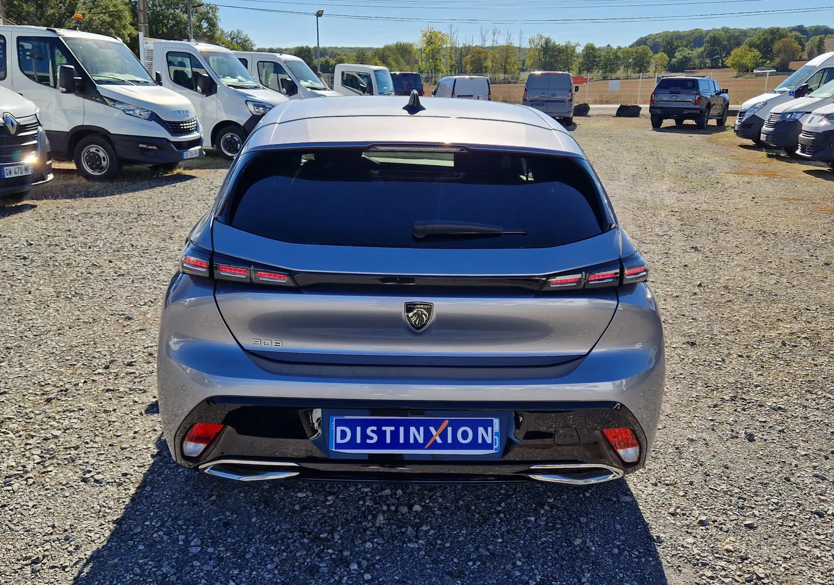 Vue arrière d'une Peugeot 308 gris Artense 2025 avec feux LED étirés et double sortie d'échappement chromée.