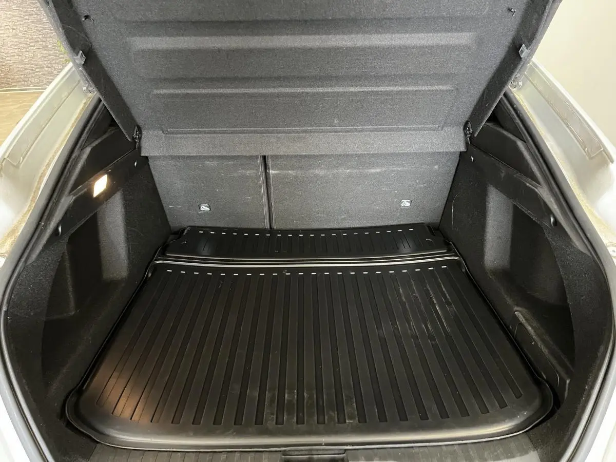 Coffre ouvert d'une Renault Arkana blanc perle, vue arrière montrant le tapis de protection noir et les parois intérieures.