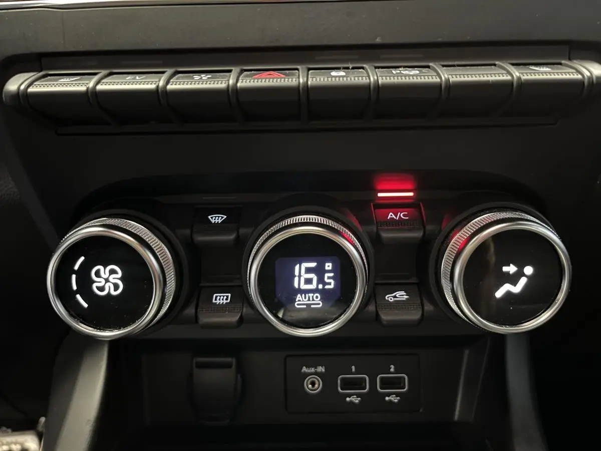 Gros plan sur les commandes de climatisation digitale du Renault Arkana R.S. Line 2022 avec boutons ronds chromés et affichage à 16,5°C.