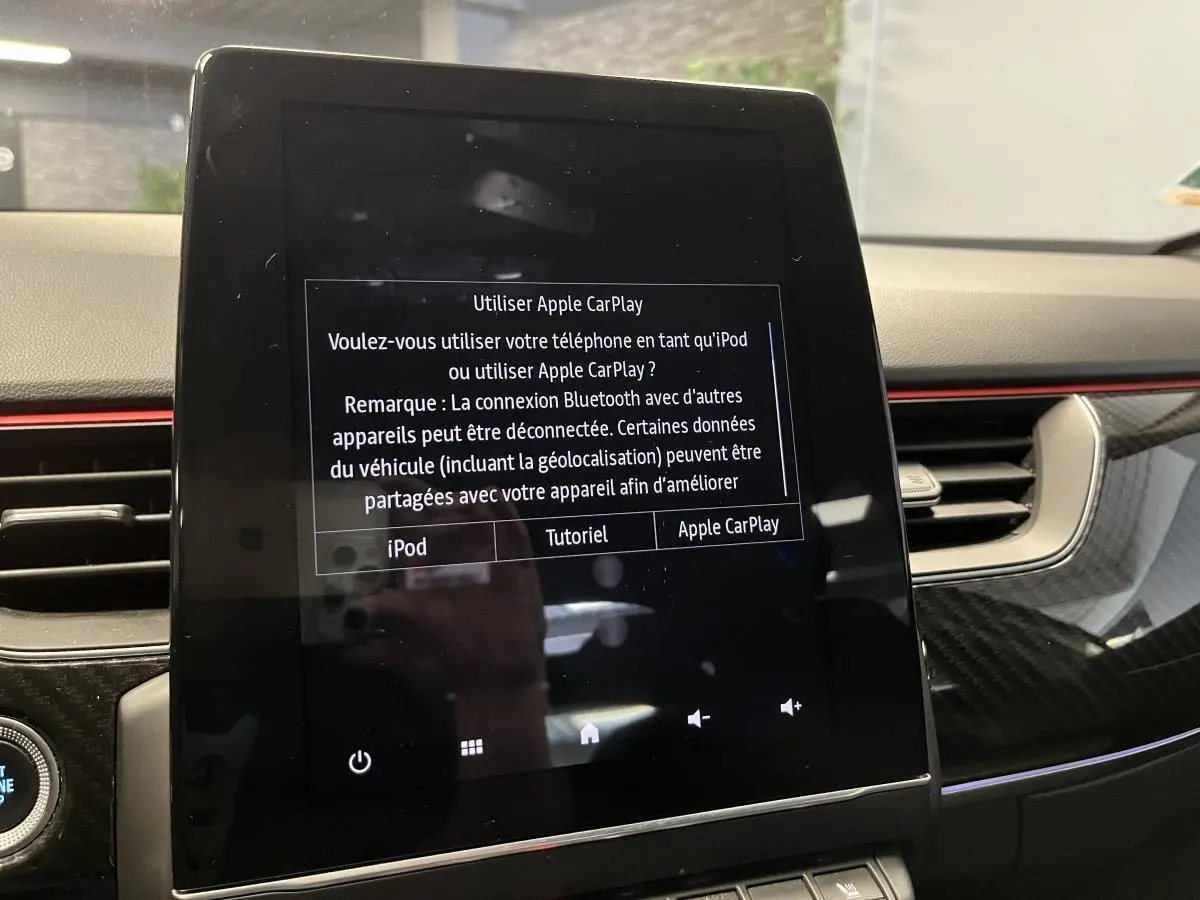 Écran tactile central affichant l'interface Apple CarPlay dans l'habitacle du Renault Arkana R.S. Line 2022.