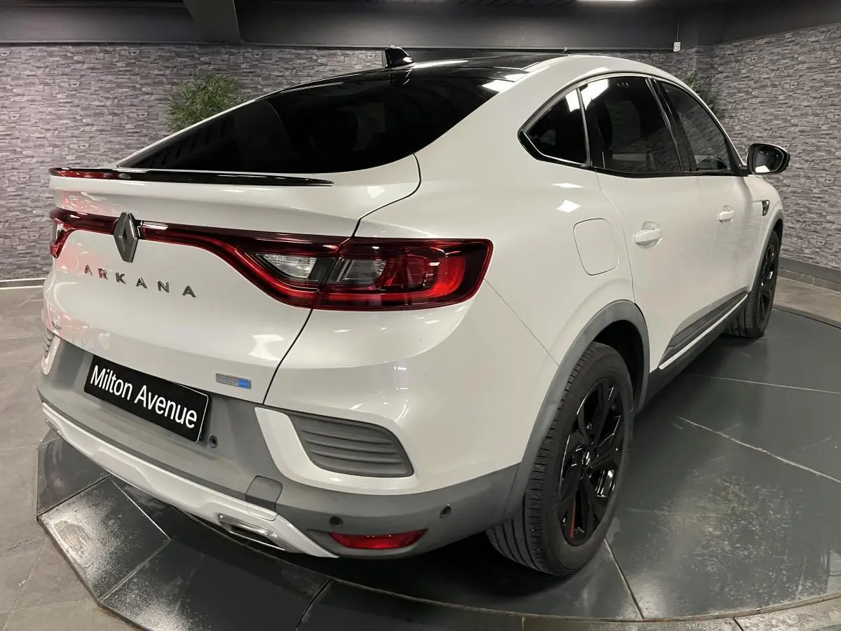 Vue 3/4 arrière droite du Renault Arkana blanc perle avec toit noir brillant et jantes noires R.S. Line.
