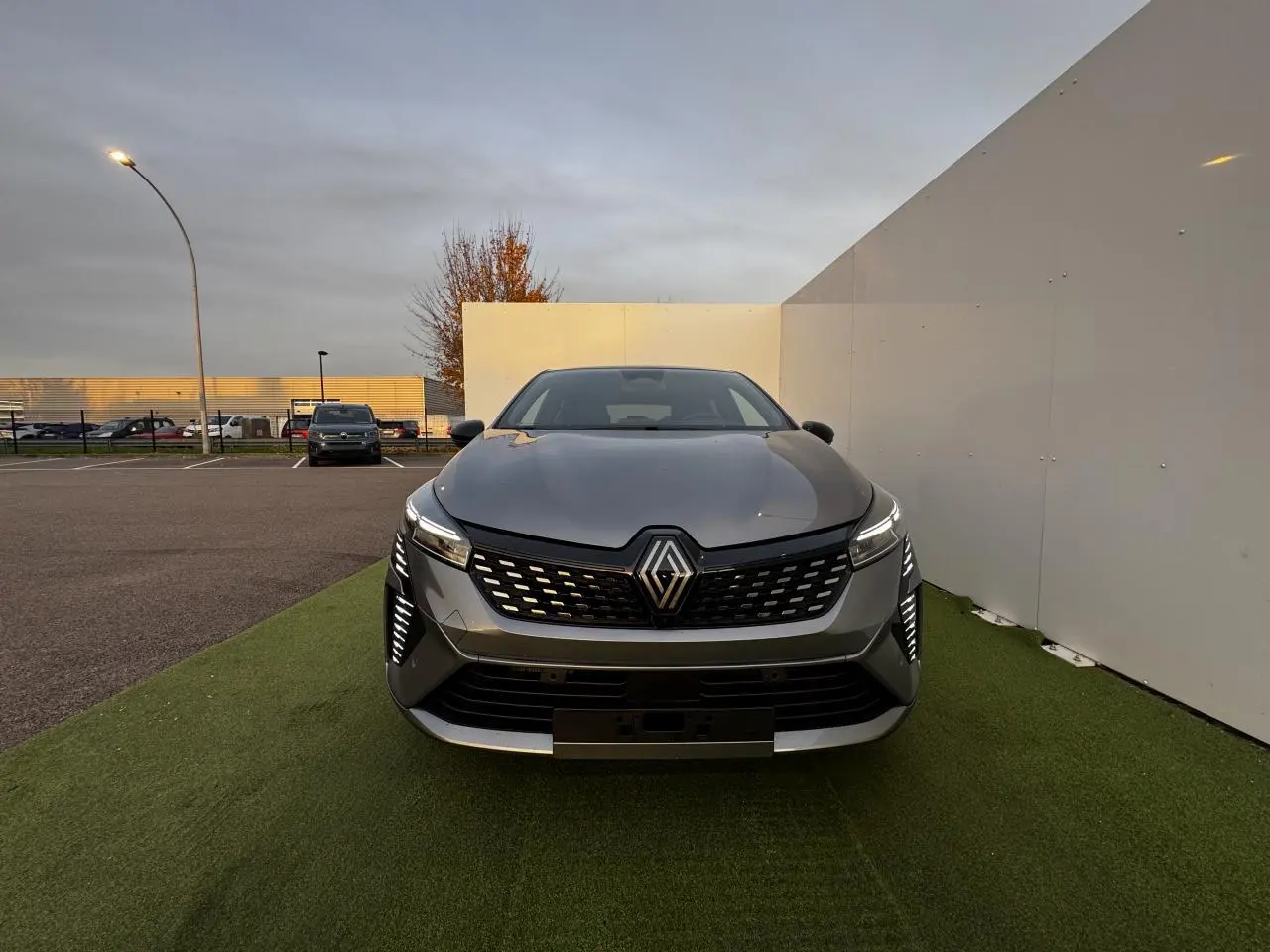 Vue frontale d'une Renault Clio 2025 gris schiste métal avec feux LED et calandre noire ajourée.