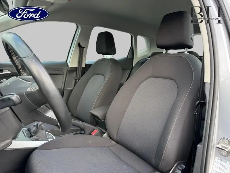Intérieur avant du SEAT ARONA 1.0 TSI 95ch Style Business 2022, sièges tissu gris et volant cuir multifonction visible côté gauche.