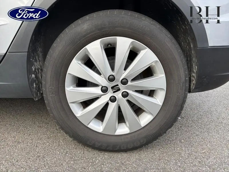 Gros plan sur la roue avant droite avec jante alu grise du SEAT ARONA Gris Urbain Métal 2022.