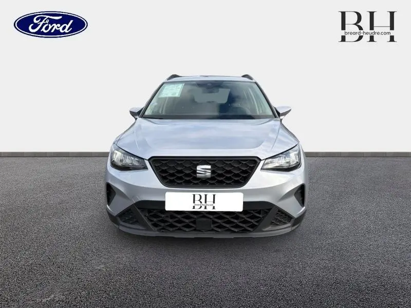Vue frontale d'un SEAT Arona gris urbain métal 2022 avec calandre noire et feux LED distinctifs.