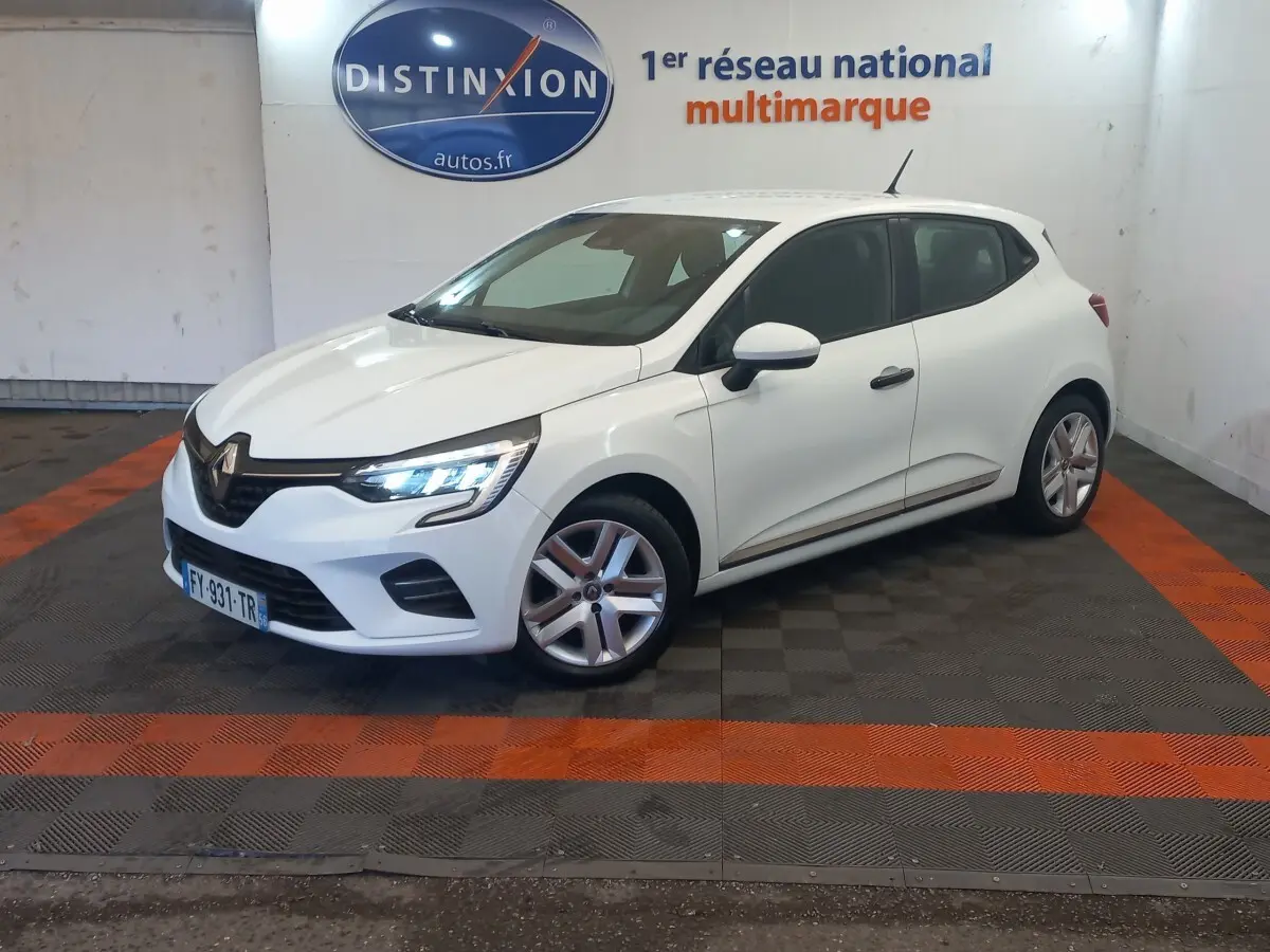 Renault Clio Business blanc vue 3/4 avant droit avec phares LED allumés dans un showroom.