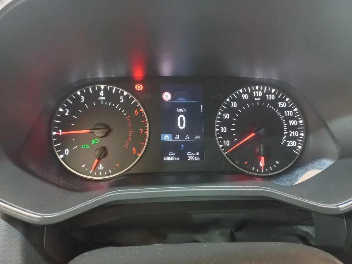 Vue rapprochée du tableau de bord numérique de la Renault Clio Business blanche, affichant 0 km/h et 43848 km au compteur.