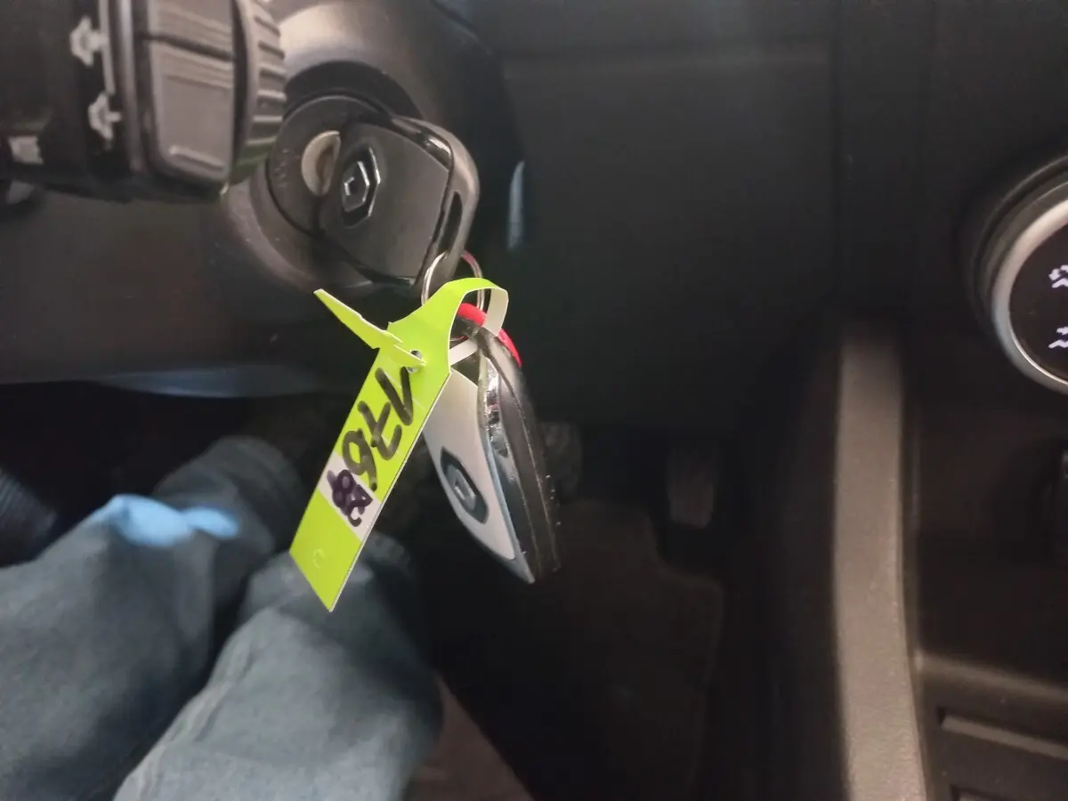 Vue intérieure du contacteur de clé Renault Clio Business 2021 avec porte-clés noir et blanc et étiquette jaune.